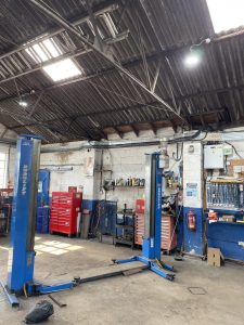 Car Lift with some nice lighting above in a garage.