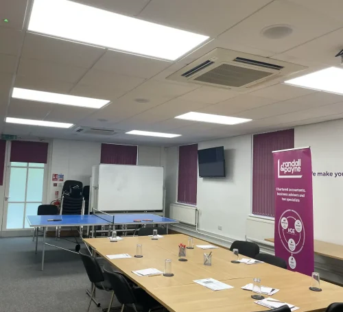 A conference room with a ping pong table in it, LED lighting above