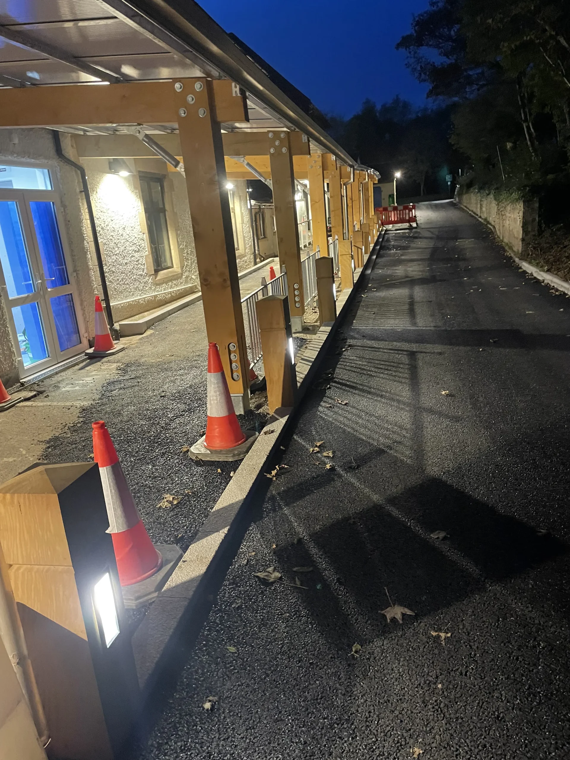 Night view of the same walkway as in image 5, shown from another angle highlighting the lighting and the wooden structure of the walkway.