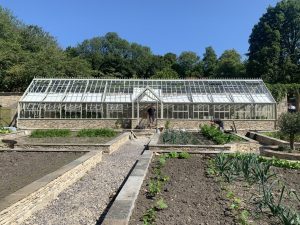 Copper-finish warm white recessed lights set into a Cotswold stone wall along a walled garden path